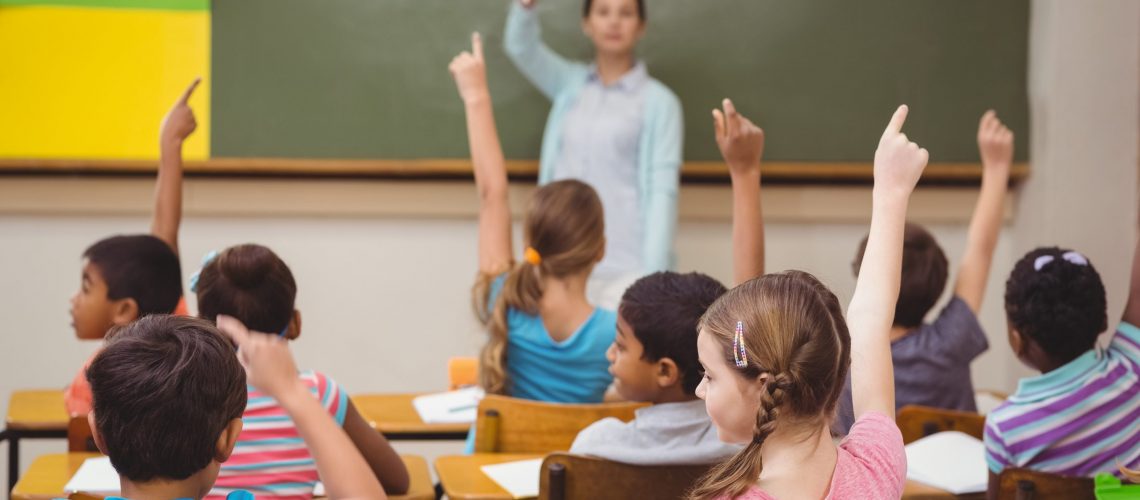 Teacher asking a question to her class at the elementary school