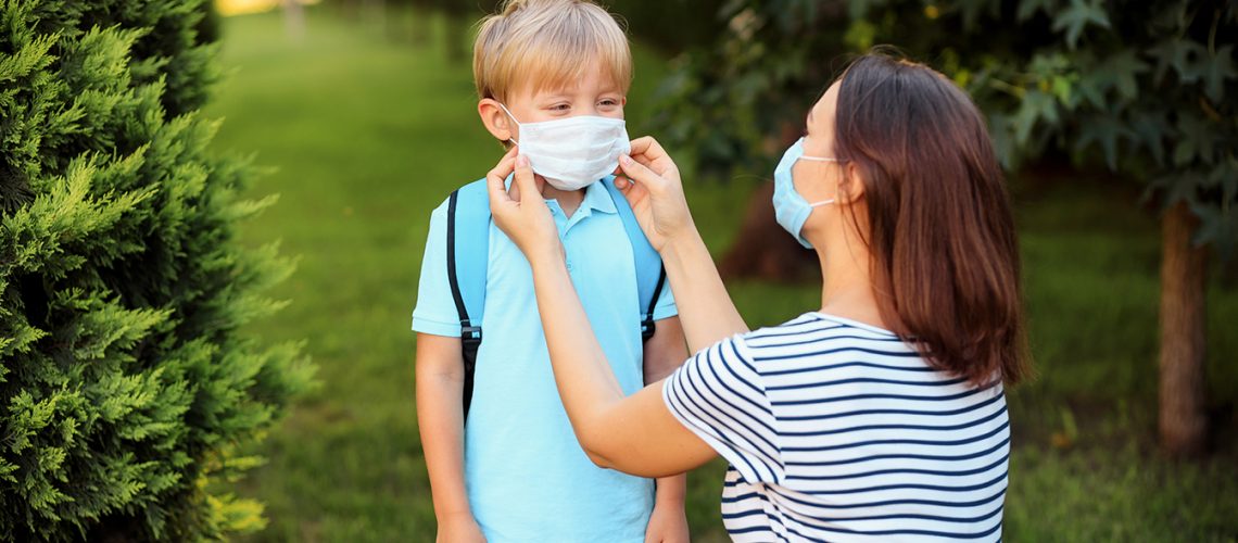 Mother and child wearing a mask go to school during an outbreak of coronavirus or flu.